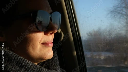 Young woman in sunglasses driving a car on rural roads