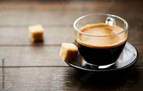 Coffee in glass cup on rustic wooden background. Copy space. 