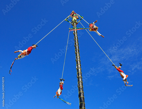 The Voladores, or flyers performance. They climb up a very high pole their waist to ropes wound around the pole and then jump off, flying gracefully around it.