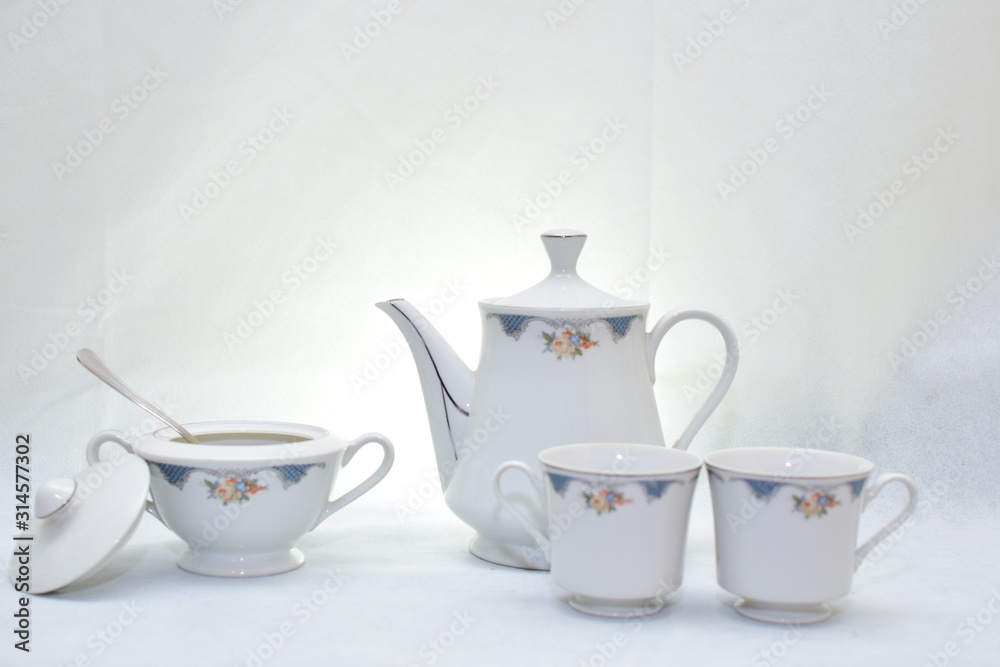 Mock up / design set of elegant and traditional teapot colorful white and blue coffee cup & Tea cup on cup's plate beside the hot tea pot , design/ drink-ware isolated on white background Mock up / design set of elegant and traditional teapot colorful white and blue coffee cup & Tea cup on cup's plate beside the hot tea pot , design/ drink-ware isolated on white background
