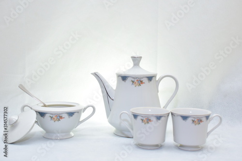 Mock up / design set of elegant and traditional teapot colorful white and blue coffee cup & Tea cup on cup's plate beside the hot tea pot , design/ drink-ware isolated on white background