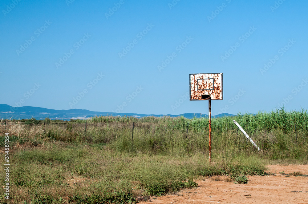 Grunge basketball board with hoop on abandoned basketball court in the beach