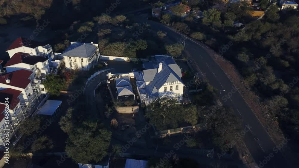 4K aerial Windhoek capital residential central hilly district bright sunset drone video with upmarket houses and old white walls German mansion on top of hill in Khomas Region, central Namibia 4K aerial Windhoek capital residential central hilly district bright sunset drone video with upmarket houses and old white walls German mansion on top of hill in Khomas Region, central Namibia