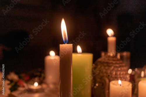 Mandala made of burning candles, flowers, a grishna idol in the dark