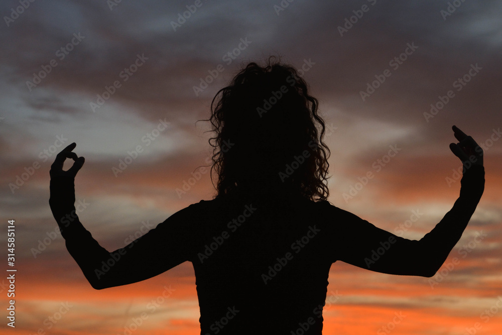 Woman doing yoga during a sunset
