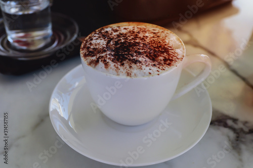 Hot cappuccino coffee in a white cup