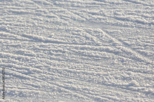 bright traces of ice skating on an ice rink. background and texture