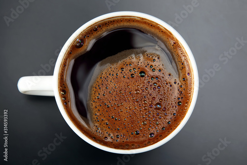 white Cup of hot black coffee on gray background