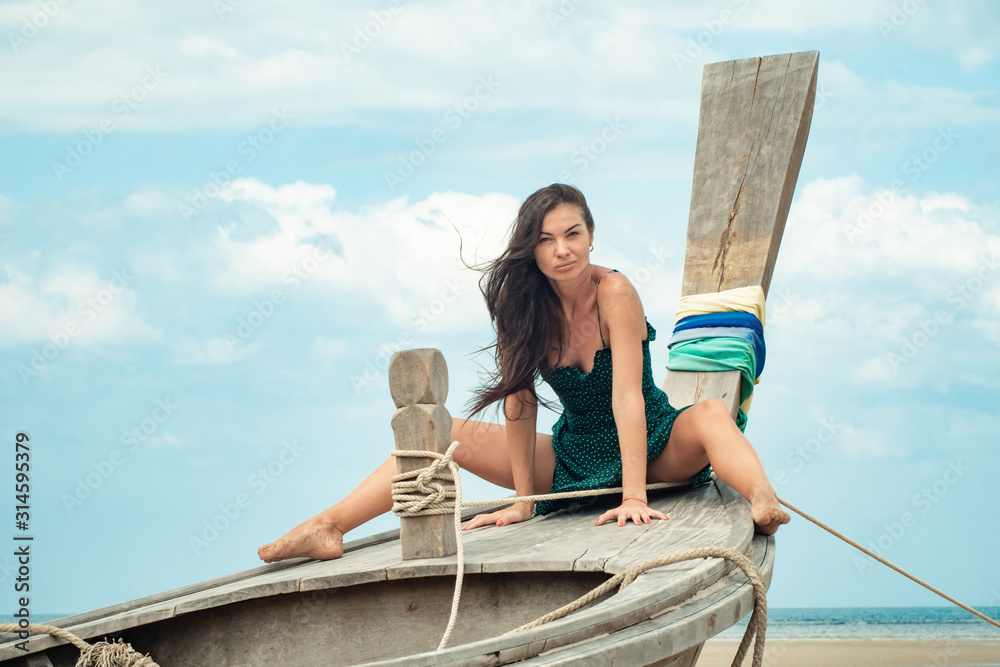 photo of a charming brunette long-haired woman on the ocean. Fashion and glam concept. Copy space