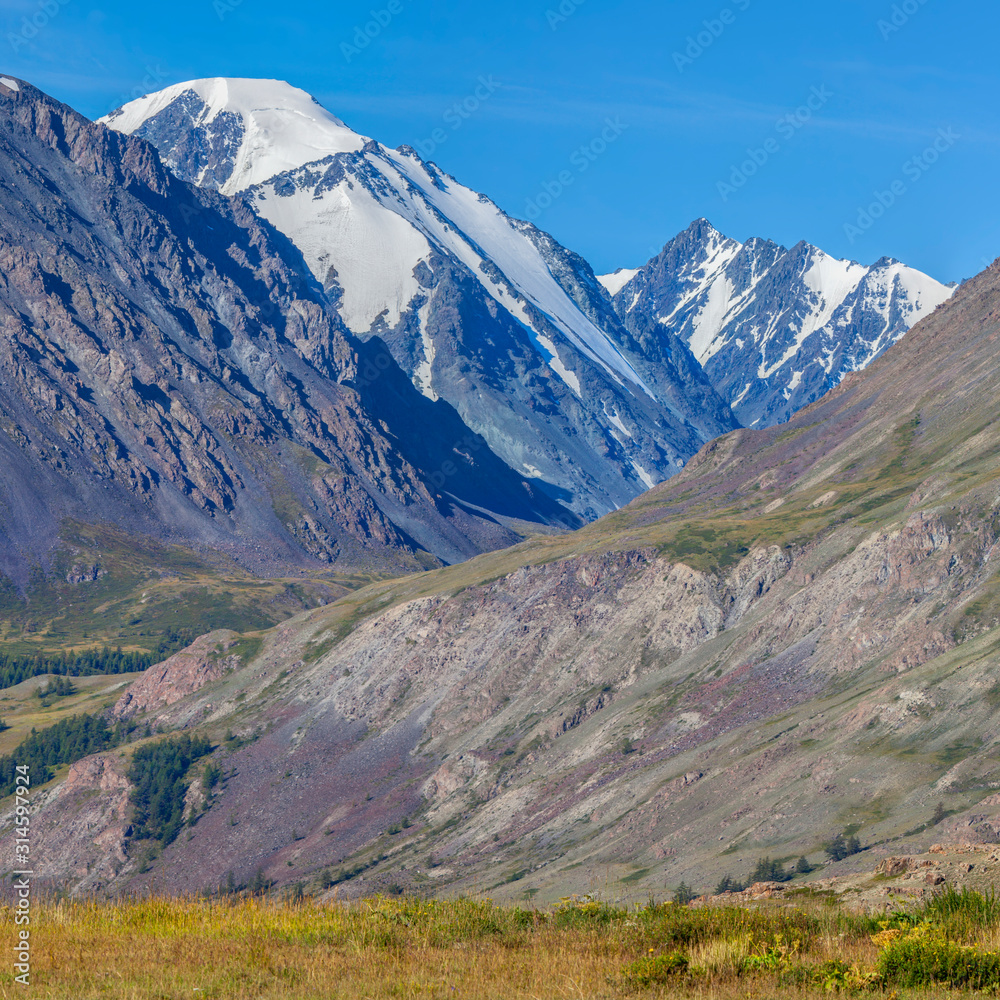 Mountain view, sunny day. Snow-capped peaks, gorge. Traveling in the mountains, climbing.