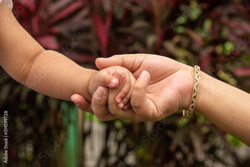 child holding mothers hands © ramkumar