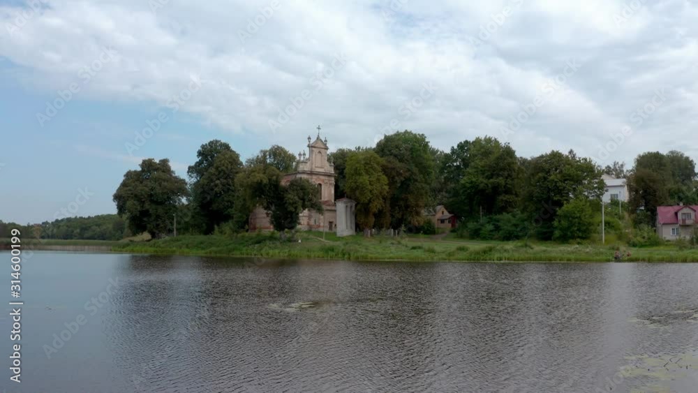 The beautiful All Saints Church in Hodovytsya, Ukraine by a calm, peaceful lake and surrounded by lush, green trees - Wide shot The beautiful All Saints Church in Hodovytsya, Ukraine by a calm, peaceful lake and surrounded by lush, green trees - Wide shot