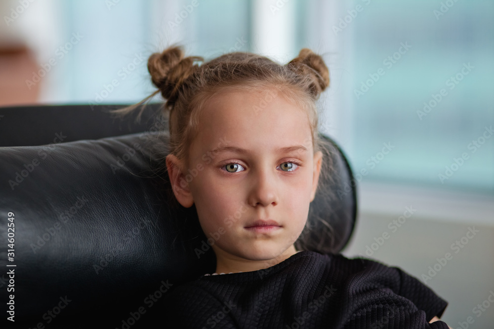 a little girl in a chair with tears in her eyes a little girl in a chair with tears in her eyes