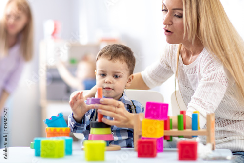 mother and her son toddler building toy pyramid tower