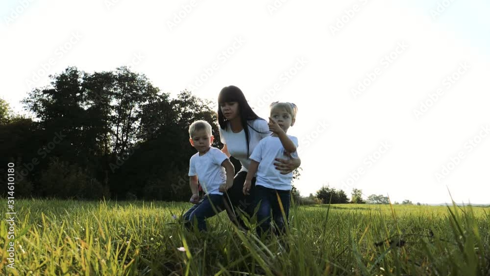 happy family concept, mom and children are resting in nature in the park. mother son and daughter sit on grass in forest summer nature vacation lifestyle concept happy family concept, mom and children are resting in nature in the park. mother son and daughter sit on grass in forest summer nature vacation lifestyle concept