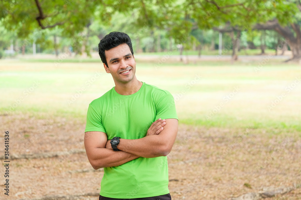 Active man in sportswear stretching one in the park, front view Active man in sportswear stretching one in the park, front view
