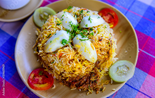 Biryani, a national Indian rice dish with masala sauce and spices. Egg Biryani rice on plate in cafe, close-up.