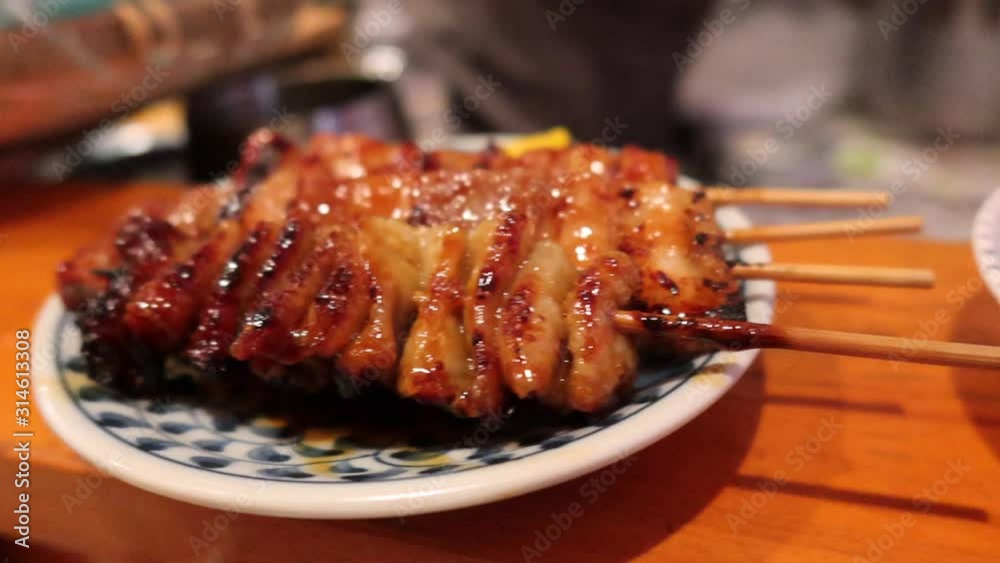 Traditional Japanese Yakitori chicken and leak sticks served in Piss alley Tokyo city Japan, 4K panning right vídeo de Stock | Adobe Stock