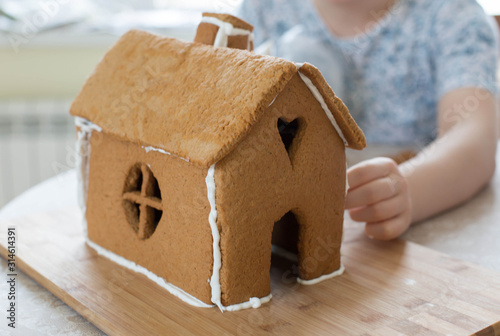 process of creating a gingerbread house. young woman makes a gingerbread house