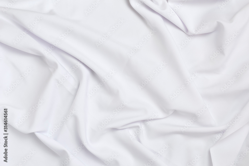 White crumpled bedding sheets. Texture fabric. Cozy background. Flat lay, top view.