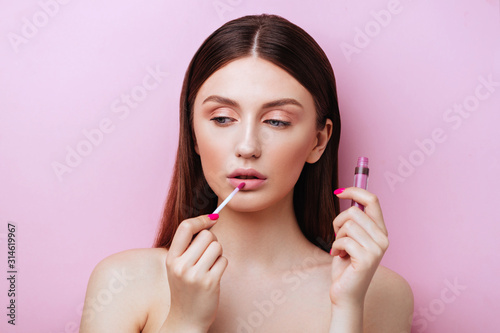 Beautiful young woman with colorful lipstick izolated on pink background