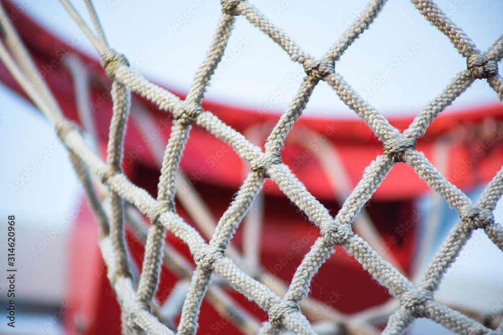 A closeup view of a basketball hoop, rim and net pattern.