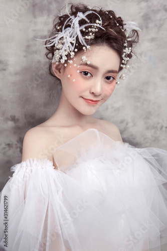 Little asian girl wearing white wedding dress and white headdress