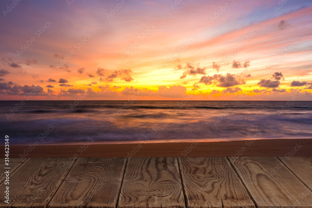 Empty wooden table with view of beautiful beach in the twilight period.