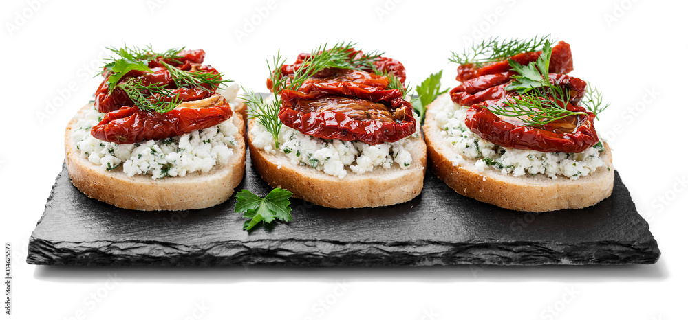 Bread slices with ricotta cheese and sun dried tomatoes in olive oil. isolated on white background Bread slices with ricotta cheese and sun dried tomatoes in olive oil. isolated on white background