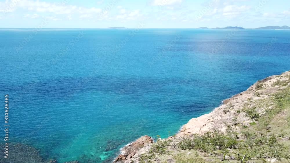 Drone flying over hillside to tropical waters of Whitsudays islands australia Drone flying over hillside to tropical waters of Whitsudays islands australia