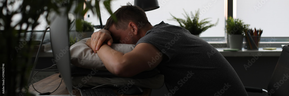 Man sleeping on office table evening time background. Man wants to go home and lives at work. Overtime night work concept. Man sleeping on office table evening time background. Man wants to go home and lives at work. Overtime night work concept.