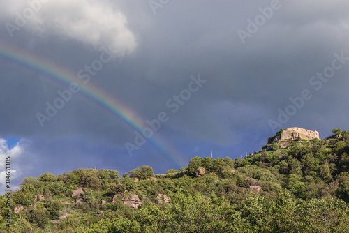 Rainbow over hill with castle ruins of Castiglione di Sicilia town on Sicily Island in Italy