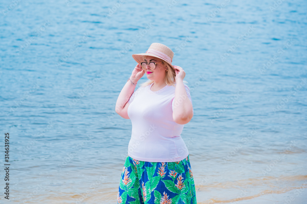 Young stylish woman walking on at nature. Casual fashion, romantic look. Plus size model. Happy overweight woman at vacation Young stylish woman walking on at nature. Casual fashion, romantic look. Plus size model. Happy overweight woman at vacation
