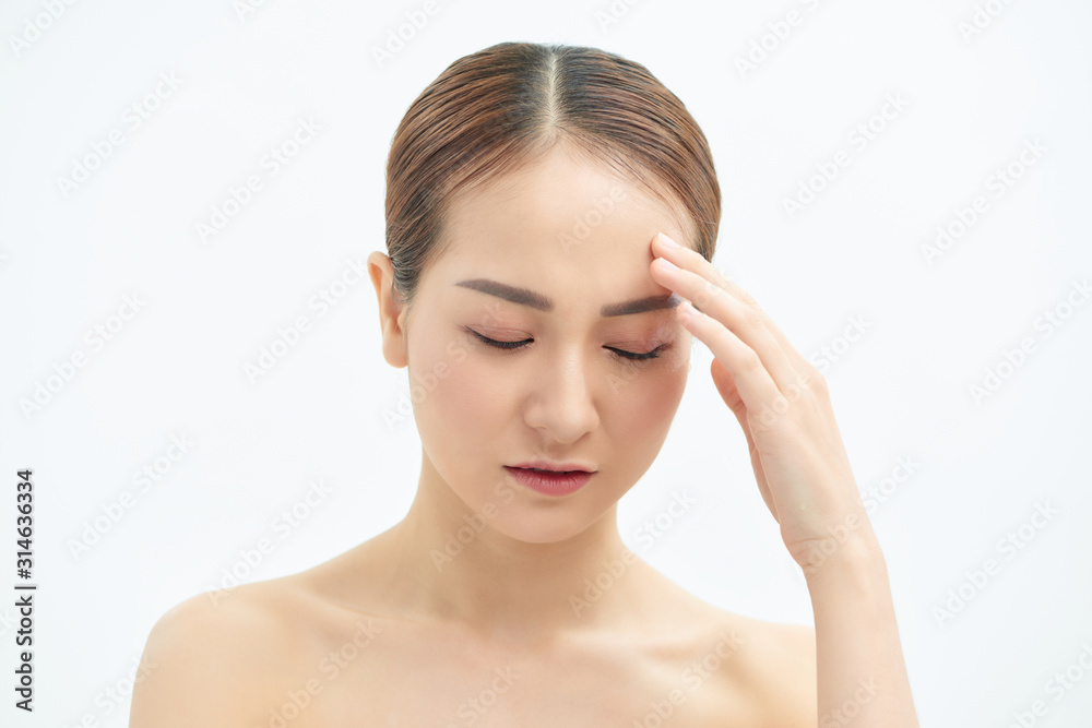 Tired and exhausted Asian woman touching her forehead over white background.