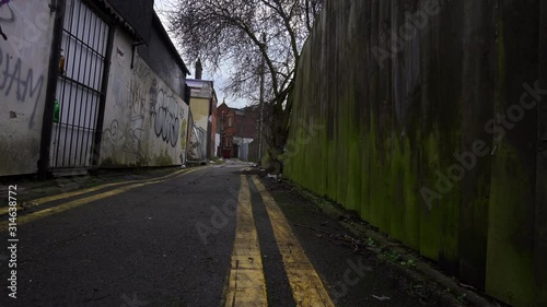 A boarded up building in the back alley of the city centre, Hanley, Stoke on Trent, UK, Litter and grafitti on the walls of the derelict abandoned building, financial crisis, highstreet demise photo