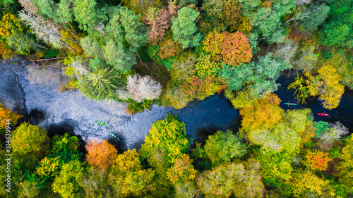 Kayaking on autumn river in forest, view from above