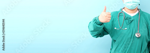 Female surgeon,surgeon showing stethoscope wearing surgeon mask, on a blue background in studio With copy space.