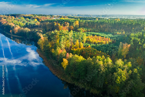 Crystal clear lake with chemtrail reflection and forest  aerial view