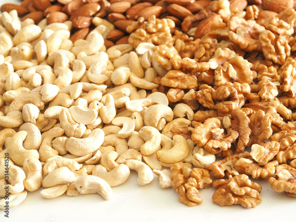 Walnuts, almonds and cashews as a background, texture and pattern. Health nuts Walnuts, almonds and cashews as a background, texture and pattern. Health nuts