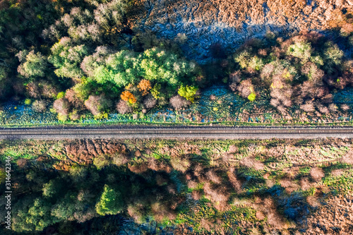 Aerial view of railway in the forest at sunrise photo