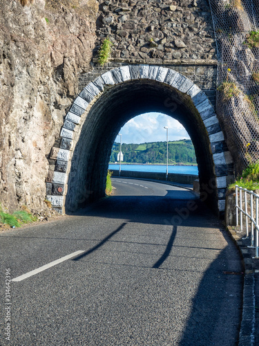Black Arc tunnel with rockfall, landslide net protection and Causeway Coastal Route. Scenic road along eastern coast of County Antrim, Northern Ireland, UK