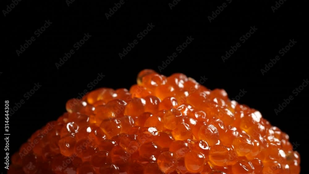 Red caviar rotated over black background. Salmon caviar close up rotation. Salted fish caviar texture. 4K 422 10 bit Red caviar rotated over black background. Salmon caviar close up rotation. Salted fish caviar texture. 4K 422 10 bit