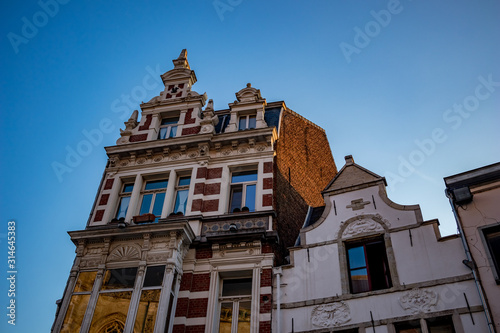 Architectural details of residential buildings. Tall corner houses near the big square. Summer evening street view near Grote Markt square of Aalst, Flanders, Belgium