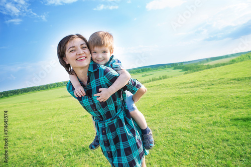 Mother and son having fun on green field