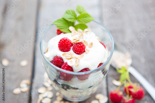 Healthy yogurt dessert with muesli, raspberries and black currants.