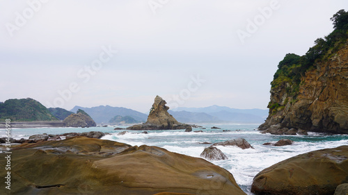 rocky ocean shore in japan. Unusually shaped volcanic rocks in the clear turquoise blue water of the Pacific Ocean. white sand on a tropical beach. cliffs of the island