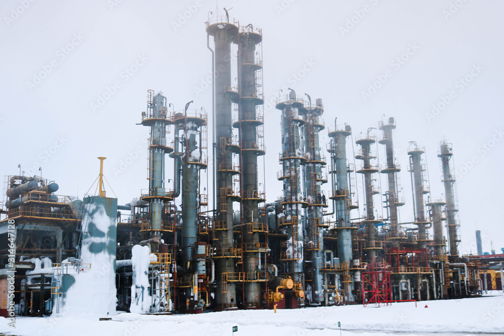 A large powerful industrial installation at an oil refining petrochemical chemical plant with pipe equipment, metal columns, barrels, barrels and equipment A large powerful industrial installation at an oil refining petrochemical chemical plant with pipe equipment, metal columns, barrels, barrels and equipment