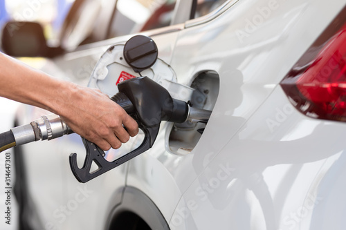 Hand refilling the car with fuel, close-up, Pumping equipment gas at gas station.