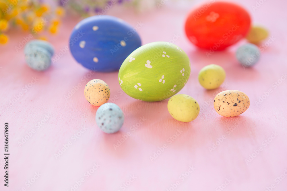 Close up of colorful easter eggs on pink wooden background