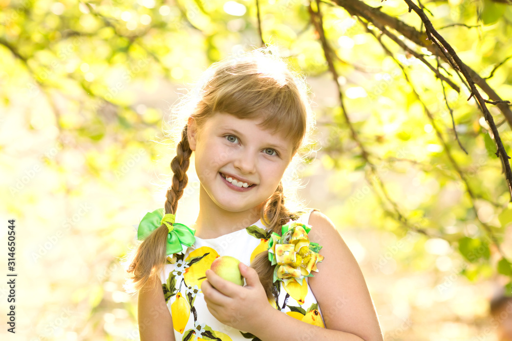 happy little girl eats apple in a garden happy little girl eats apple in a garden